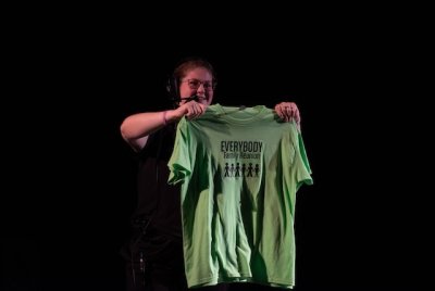 Student stage manager holds out a green t-shirt