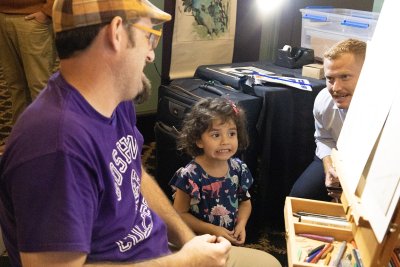 a young child grimaces at her caricature.