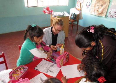 Miss Anna helping a student in the classroom.